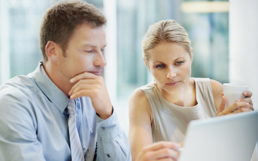 Portrait of attractive business people using laptop together at office